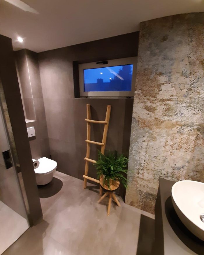 Badkamer met natuursteenlook, zwevend toilet en losse waskom