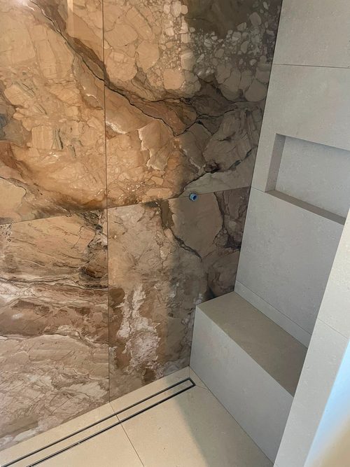 Gemetselde zitbank in de douche, douchegoot langs de wand