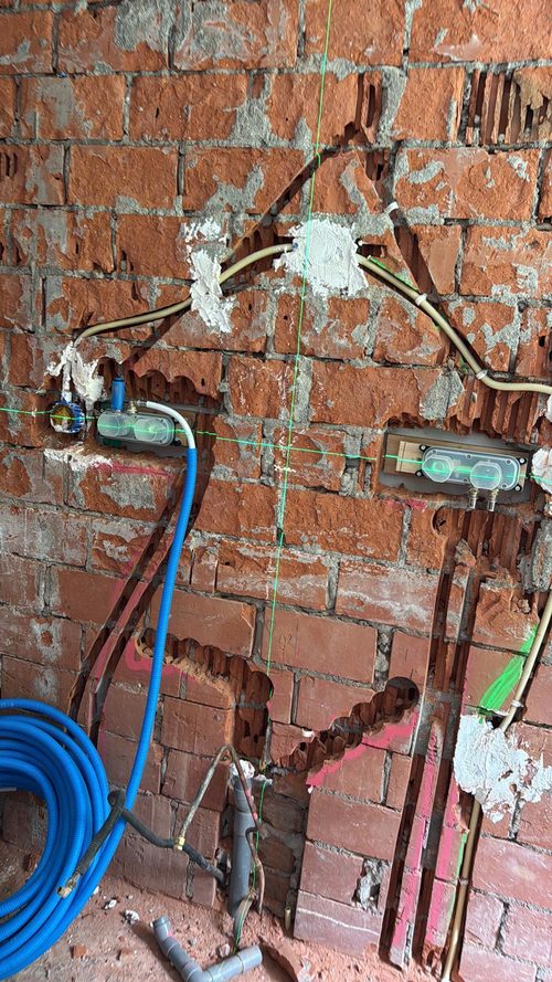 Leidingwerk op de bakstenen wand, afvoer al gezet