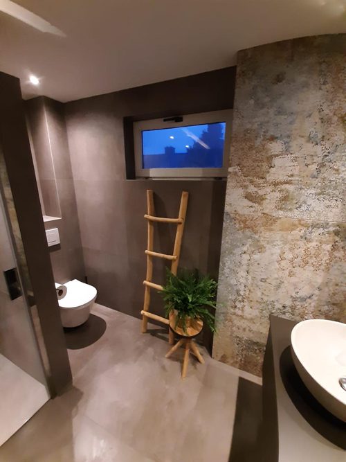 Natuursteenlook wandtegels, zwevend toilet, inbouwreservoir weggewerkt
